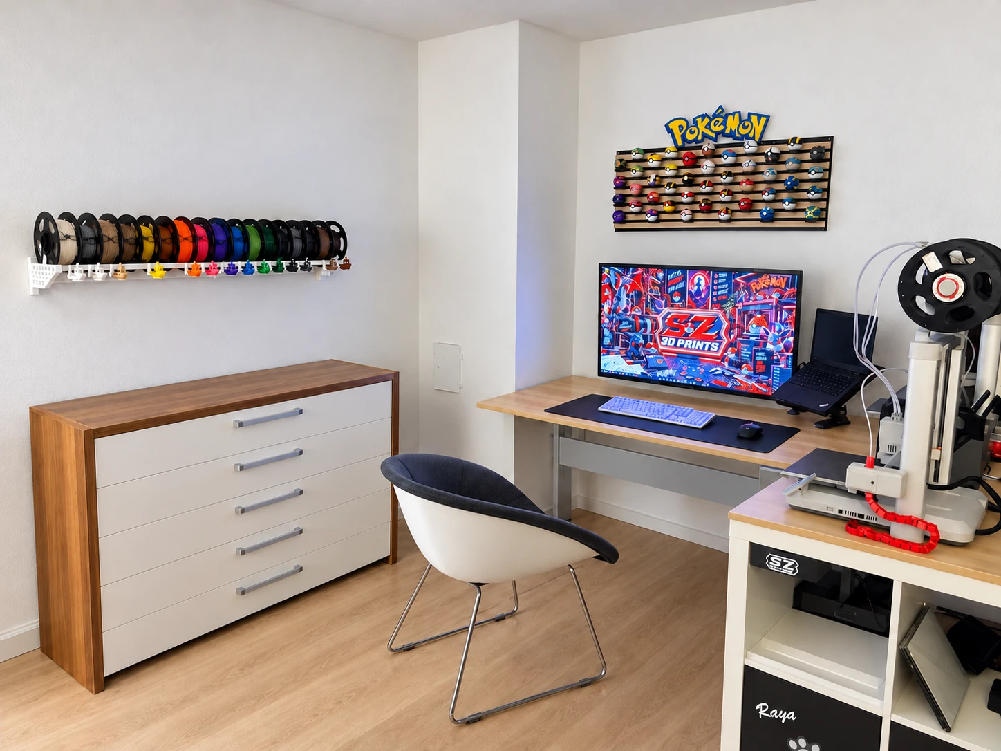 Werkstatt mit farbig sortierten Filamentrollen, Schreibtisch und Pokéball-Wanddisplay